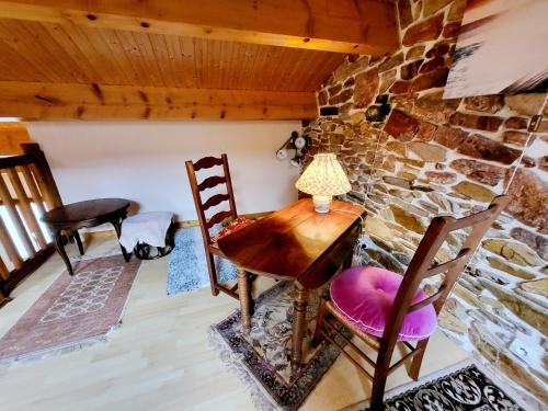 une table et des chaises dans une pièce avec un mur en pierre dans l'établissement Maison T4 avec Garage et WiFi à 300m de la Plage - Quartier Arago - FR-1-92-655, à Les Sables-dʼOlonne