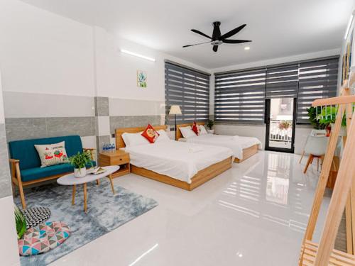 a bedroom with a bed and a couch and a fan at ALOHA SAIGON PREMIUM HOSTEL by Local Travel Experts - Newly opened, Less-touristy location, Spacious rooms, Glass shower bathroom, Free breakfast & Walking Tour in Ho Chi Minh City