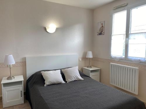 une chambre avec un lit avec deux tables et deux lampes dans l'établissement Maison à 50m de la plage avec jardin clos et wifi - La Tranche-sur-Mer - FR-1-22-314, à La Tranche-sur-Mer