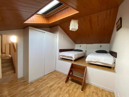 Cette chambre au plafond comprend 2 lits sur un bureau. dans l'établissement Maison à 50m de la plage avec jardin clos et wifi - La Tranche-sur-Mer - FR-1-22-314, à La Tranche-sur-Mer