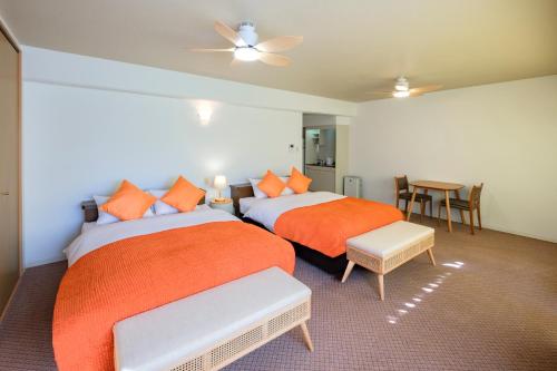宮崎市にある宮崎マンゴーホテルのベッドルーム1室(ベッド2台、テーブル、椅子付)