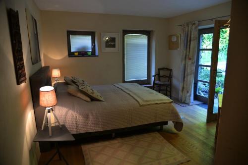 a bedroom with a bed and a table with a lamp at La Renardière à Malmedy, près du circuit de Francorchamps in Malmedy