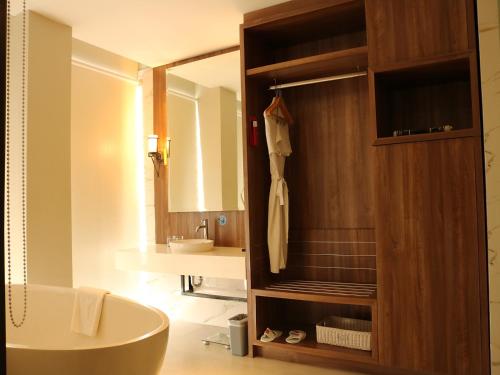 a bathroom with a bath tub and a sink at Emersia Hotel & Resort Batusangkar in Batusangkar