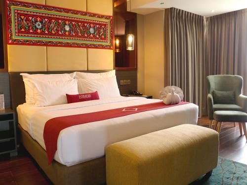 Emersia Hotel & Resort Batusangkar في Batusangkar: غرفة نوم بسرير كبير عليها دبدوب