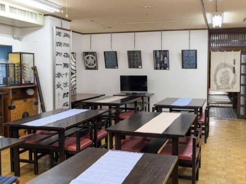 una clase con mesas y sillas en una habitación en Guest houseTakagi - Vacation STAY 60566v, en Matsumoto