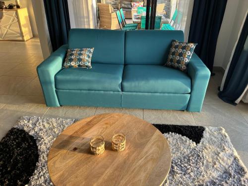 a blue couch and a coffee table in a living room at La villa O'rizon in Le Diamant