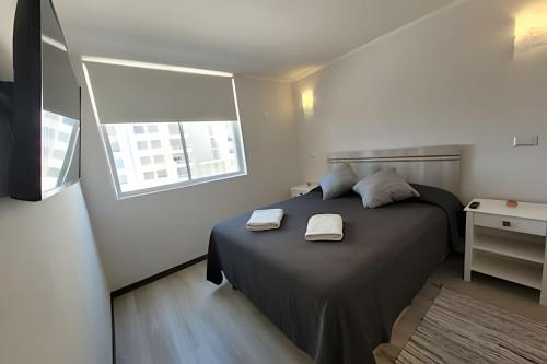 ein Schlafzimmer mit einem Bett mit zwei Handtüchern darauf in der Unterkunft Condominio Pacífico 3100 in La Serena