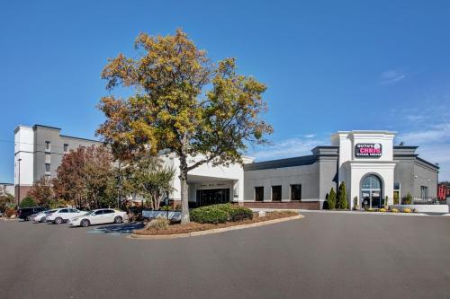 a building with cars parked in a parking lot at Crowne Plaza Greenville by IHG in Greenville