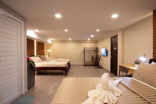 Cette chambre comprend 2 lits et une télévision. dans l'établissement Gate78 Hostel Maephim Beach, à Mae Pim