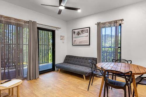 a living room with a couch and a table at Kipara Tropical Rainforest Retreat in Airlie Beach