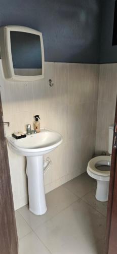 y baño con lavabo y aseo. en Casa Vila da gloria, en São Francisco do Sul