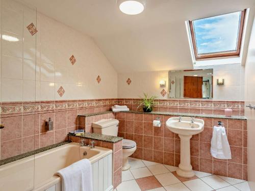 a bathroom with a tub and a sink and a toilet at 3 Bed in Holywell 89614 in Whitford