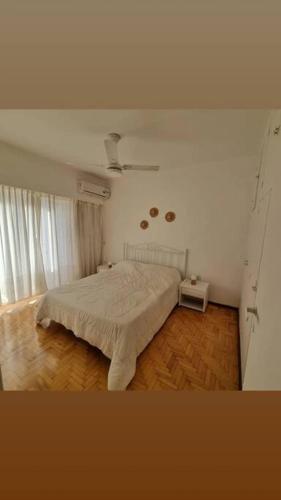 1 dormitorio con cama blanca y suelo de madera en Céntrico , Ideal para familias y amigos ! en Rosario
