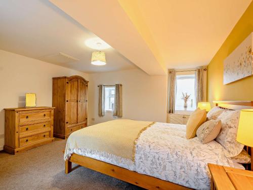 a bedroom with a large bed and a wooden dresser at 2 Bed in Falkirk 90602 in Bonnybridge