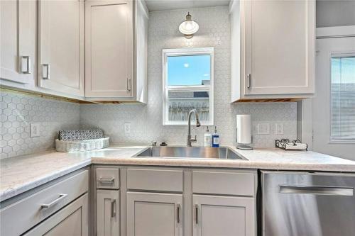 a kitchen with white cabinets and a sink and a window at House of Charm! Bike Trails & New Walmart HQ in Bentonville