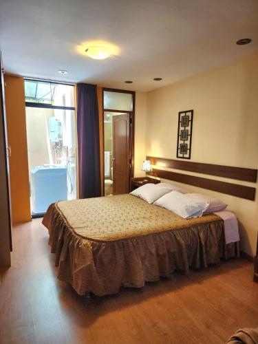 a bedroom with a bed and a large window at Challapampa Apart Arequipa in Arequipa