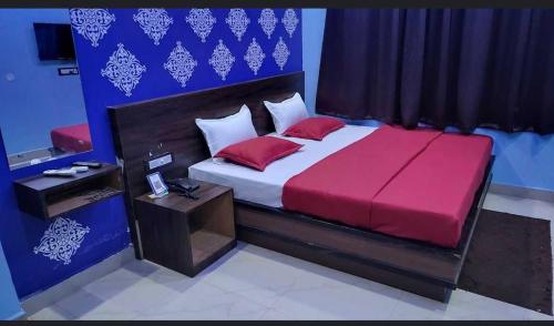 Un dormitorio con una cama grande con sábanas rojas y una mesa. en OYO The Mount View en Jamshedpur