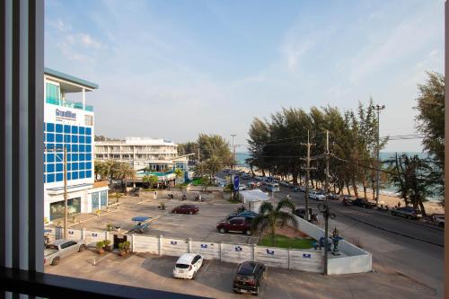 a city street with cars parked in a parking lot at Gate78 Hostel Maephim Beach in Mae Pim