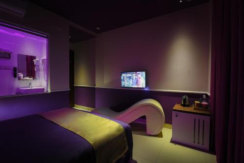 una camera con letto, lavandino e illuminazione viola di Chiic House 4 - Khách sạn tình yêu a Quy Nhon