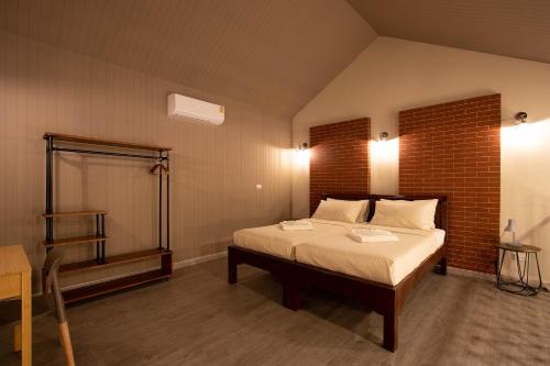 a bedroom with a bed and a brick wall at Gate78 Hostel Maephim Beach in Mae Pim
