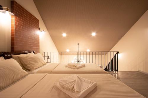 a bedroom with two beds with white sheets at Gate78 Hostel Maephim Beach in Mae Pim