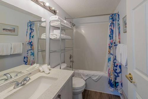 a bathroom with a sink and a toilet and a shower at B211 MTN View ground floor town house- 2BD, Sleeps 8, hot tub, free parking, close to Banff in Canmore