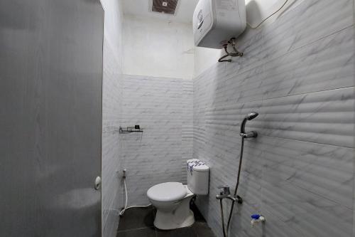 y baño blanco con aseo y ducha. en Residence Syariah, en Binjai