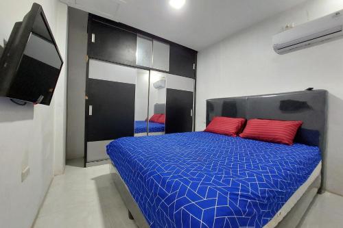 1 dormitorio con 1 cama azul y 2 almohadas rojas en Residence Syariah, en Binjai