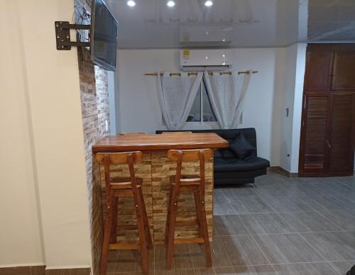 a kitchen with a bar with stools and a couch at El santorini colombiano en Doradal in Puerto Triunfo