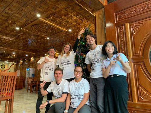 a group of people posing for a picture in front of a christmas tree at Sun Hà Giang Hotel-tours-motorbike rental in Ha Giang