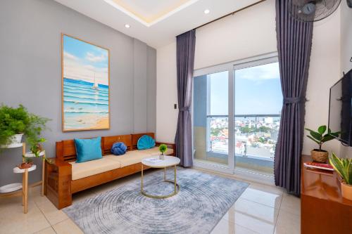 a living room with a couch and a large window at Prague Hotel Vung Tau in Vung Tau