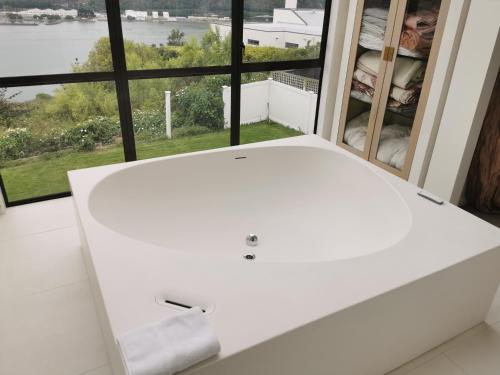 a white couch in front of a large window at Luxury Harbour view in Dunedin