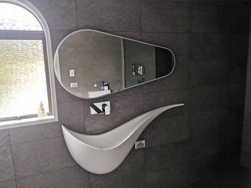 a white tub in a bathroom with a mirror at Luxury Harbour view in Dunedin