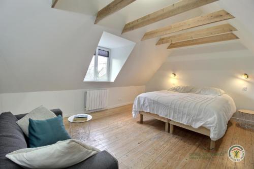 ein Schlafzimmer mit einem Bett und einem Sofa in einem Zimmer in der Unterkunft Kermaria in Plougrescant