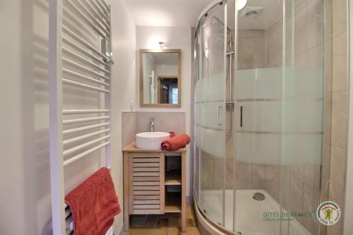 ein Bad mit einer Dusche und einem Waschbecken in der Unterkunft Kermaria in Plougrescant