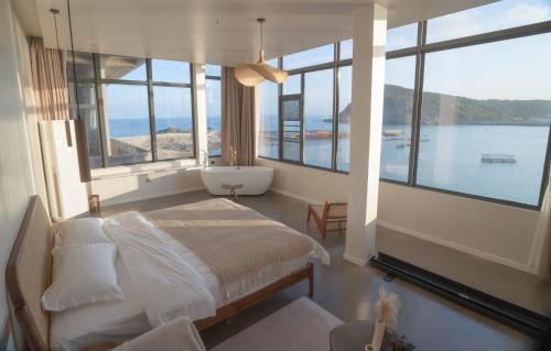 a bedroom with a bed and a view of the water at 一抹云海景民宿 in Pingtan