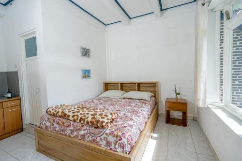 a bedroom with a bed in a room with windows at Sekar Gambir Homestay in Batu