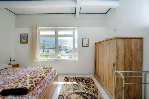 a bedroom with a bed and a window at Sekar Gambir Homestay in Batu
