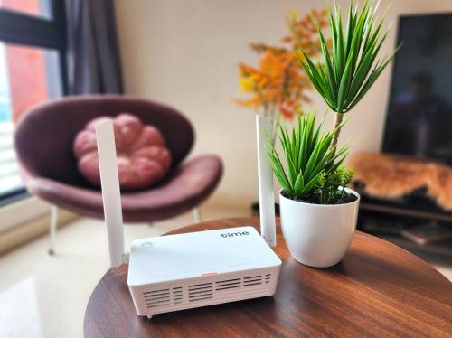a table with a modem and a potted plant on it at Loft Suite Central City 2BR JB CIQ 7Pax in Johor Bahru