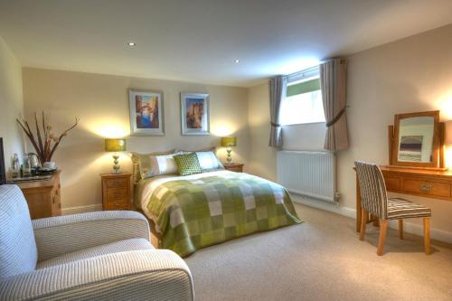 East HarlingにあるSunset House Bed and Breakfastのベッドルーム1室(ベッド1台、ソファ、椅子付)