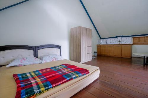 a bedroom with a bed with a colorful blanket on it at Sekar Gambir Homestay in Batu