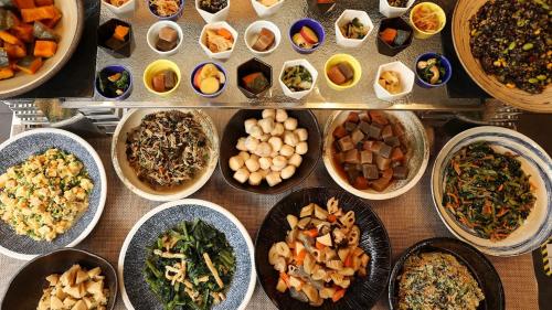 a table topped with bowls of different types of food at Urban Hotel Kyoto Shijo Premium in Kyoto