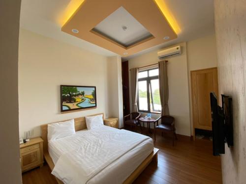 ein Schlafzimmer mit einem weißen Bett und einem Tisch in der Unterkunft Hotel Như ý Biên Hòa in Biên Hòa