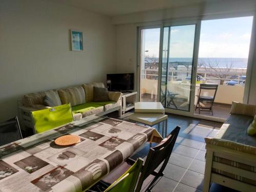 un salon avec une table et un canapé dans l'établissement Appartement moderne 2 chambres avec terrasse, proche plage et commerces - FR-1-323-491, à Saint-Jean-de-Monts