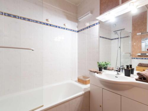 ein weißes Badezimmer mit einer Badewanne und einem Waschbecken in der Unterkunft Studio Saint-Lary-Soulan, 1 pièce, 5 personnes - FR-1-296-492 in Saint-Lary-Soulan