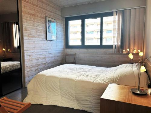 um quarto com uma cama branca e uma janela em Appartement Le Lavandou, 2 pièces, 4 personnes - FR-1-251-581 em Le Lavandou