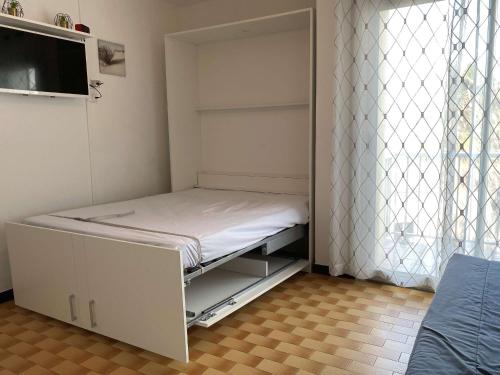 une petite pièce avec un lit et une fenêtre dans l'établissement Beau studio rénové 2 pers, climatisé, proche thermes, Parc Charles de Gaulle, balcon, 2 étoiles - FR-1-553-240, à Balaruc-les-Bains