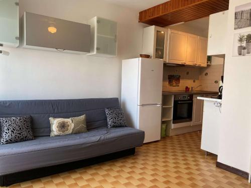 un salon avec un canapé bleu dans une cuisine dans l'établissement Beau studio rénové 2 pers, climatisé, proche thermes, Parc Charles de Gaulle, balcon, 2 étoiles - FR-1-553-240, à Balaruc-les-Bains