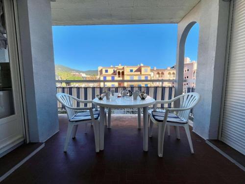 une table blanche et des chaises sur un balcon avec vue dans l'établissement Appartement Climatisé Proche Plage et Commerces - 2 Pièces, 4 Pers, Parking Privé, Animaux Acceptés - FR-1-226B-177, à Cavalaire-sur-Mer