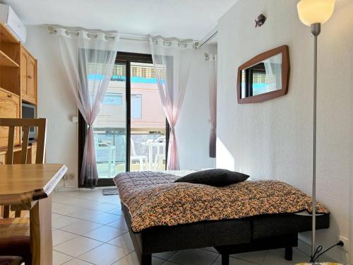 une chambre avec un lit, une table et une fenêtre dans l'établissement Appartement climatisé, 4 couchages, centre-ville du Lavandou, proche plage, parking inclus - FR-1-251-580, au Lavandou